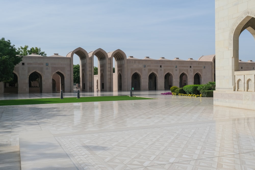 a courtyard with arches and grass in the middle