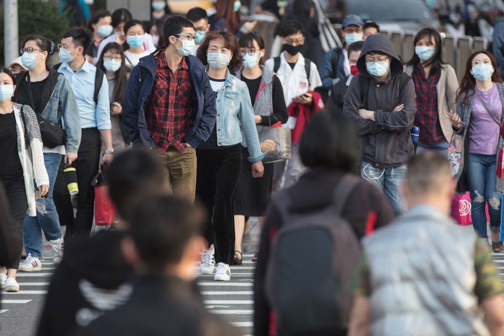 a large group of people walking across a street