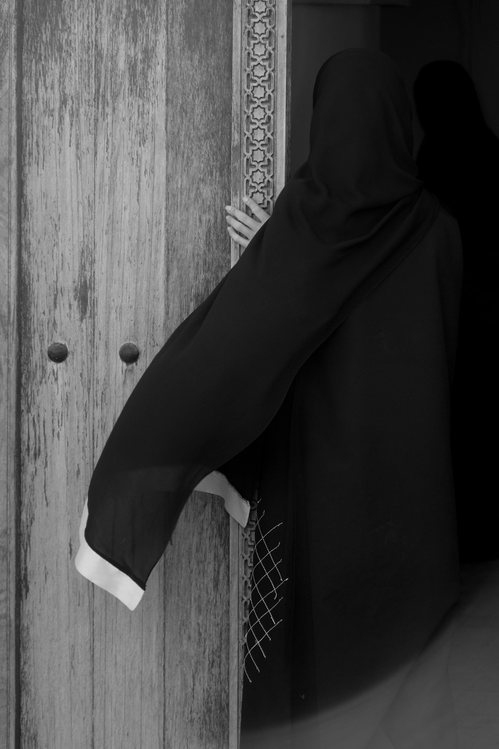 a person in a black robe is opening a door