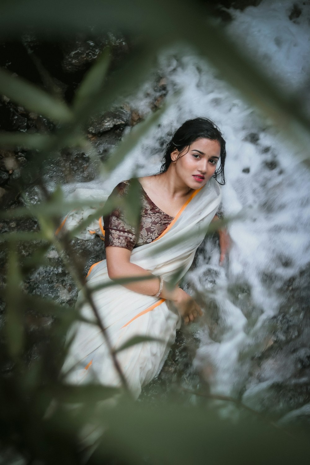 uma mulher em um sari sentado em uma rocha