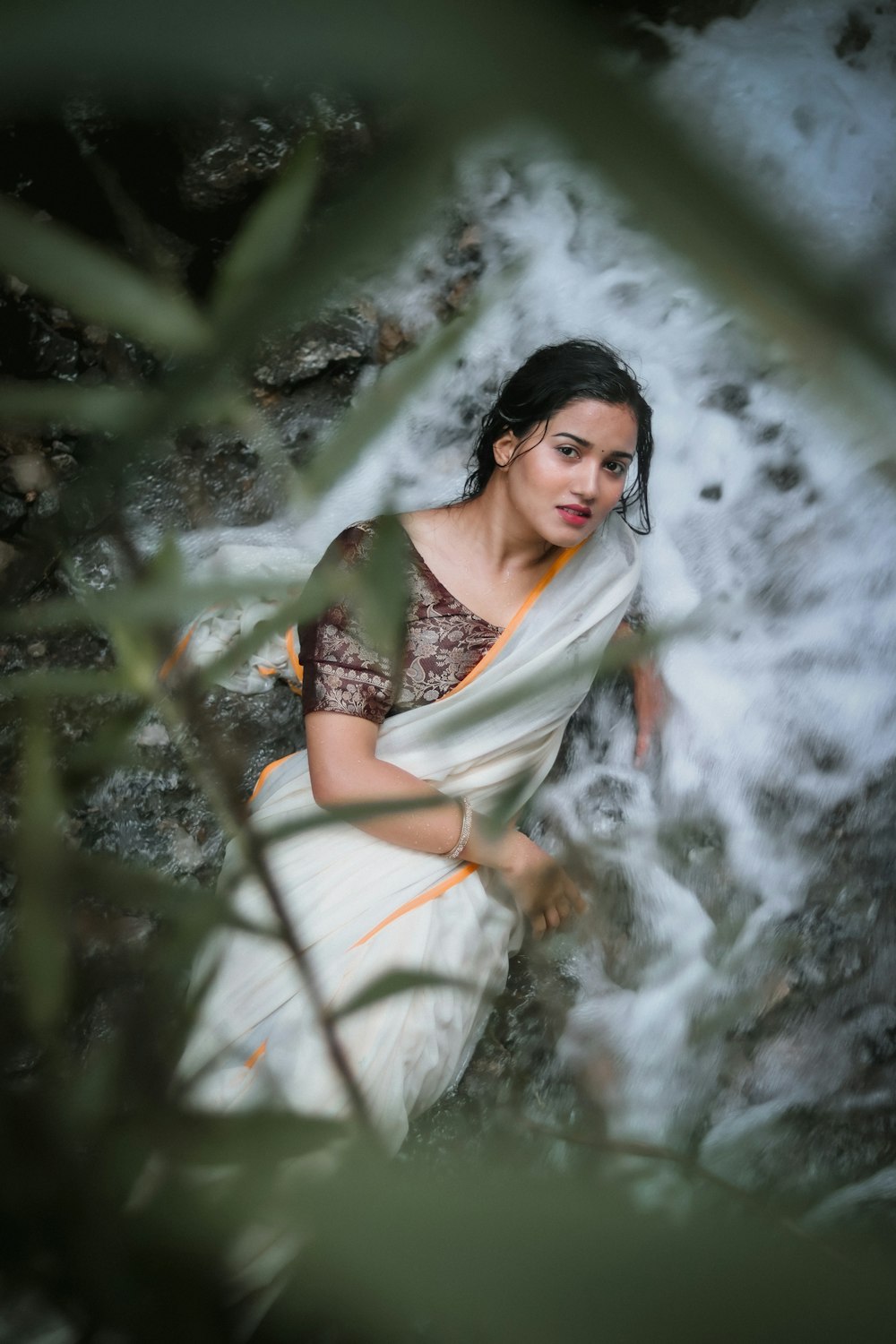 a woman in a sari sitting on a rock