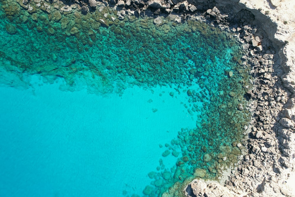 an aerial view of a body of water surrounded by rocks