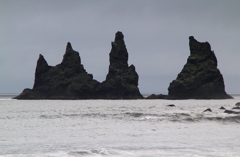 a group of rocks sticking out of the ocean