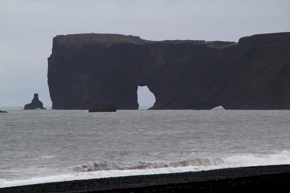 a large rock formation in the middle of a body of water