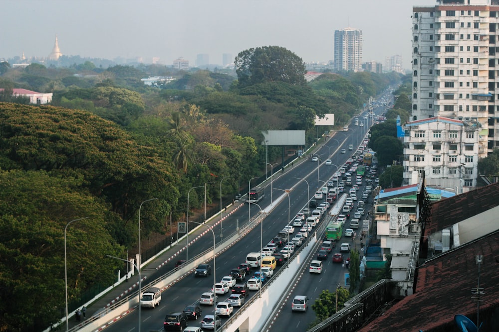 a city street filled with lots of traffic next to tall buildings