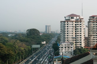 a city street filled with lots of traffic next to tall buildings