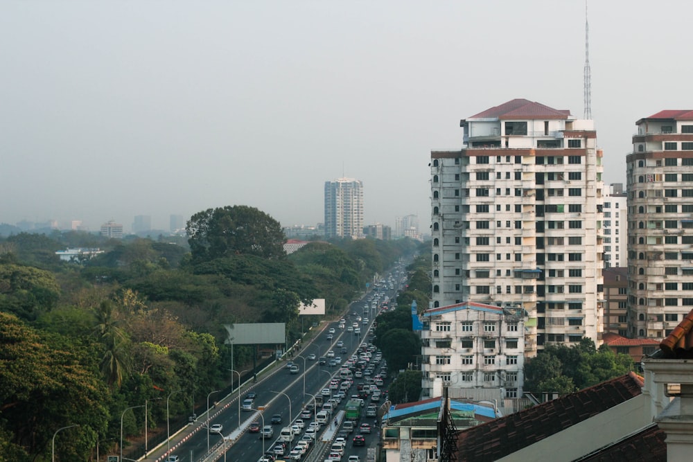 a city street filled with lots of traffic next to tall buildings