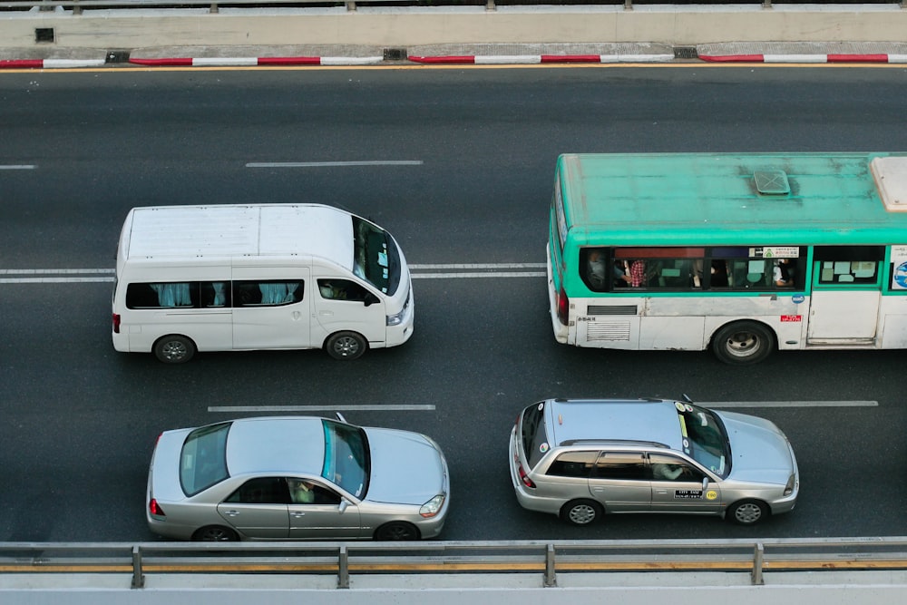 a green and white bus driving down a street