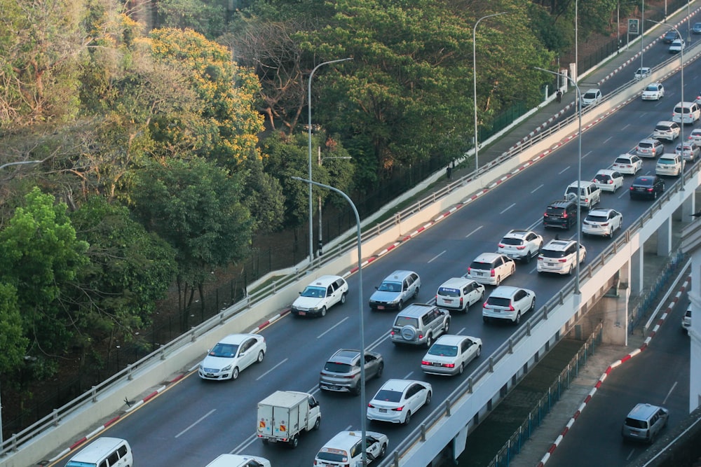 a highway filled with lots of traffic next to a forest