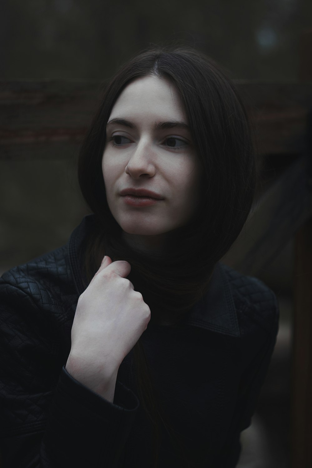 a woman in a black jacket is posing for a picture