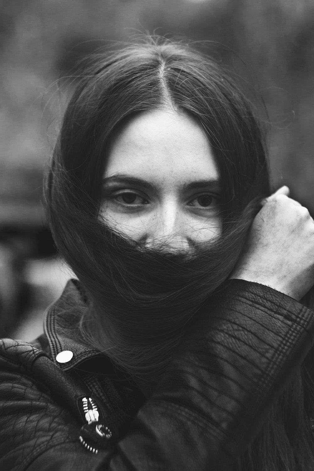 a black and white photo of a woman covering her face