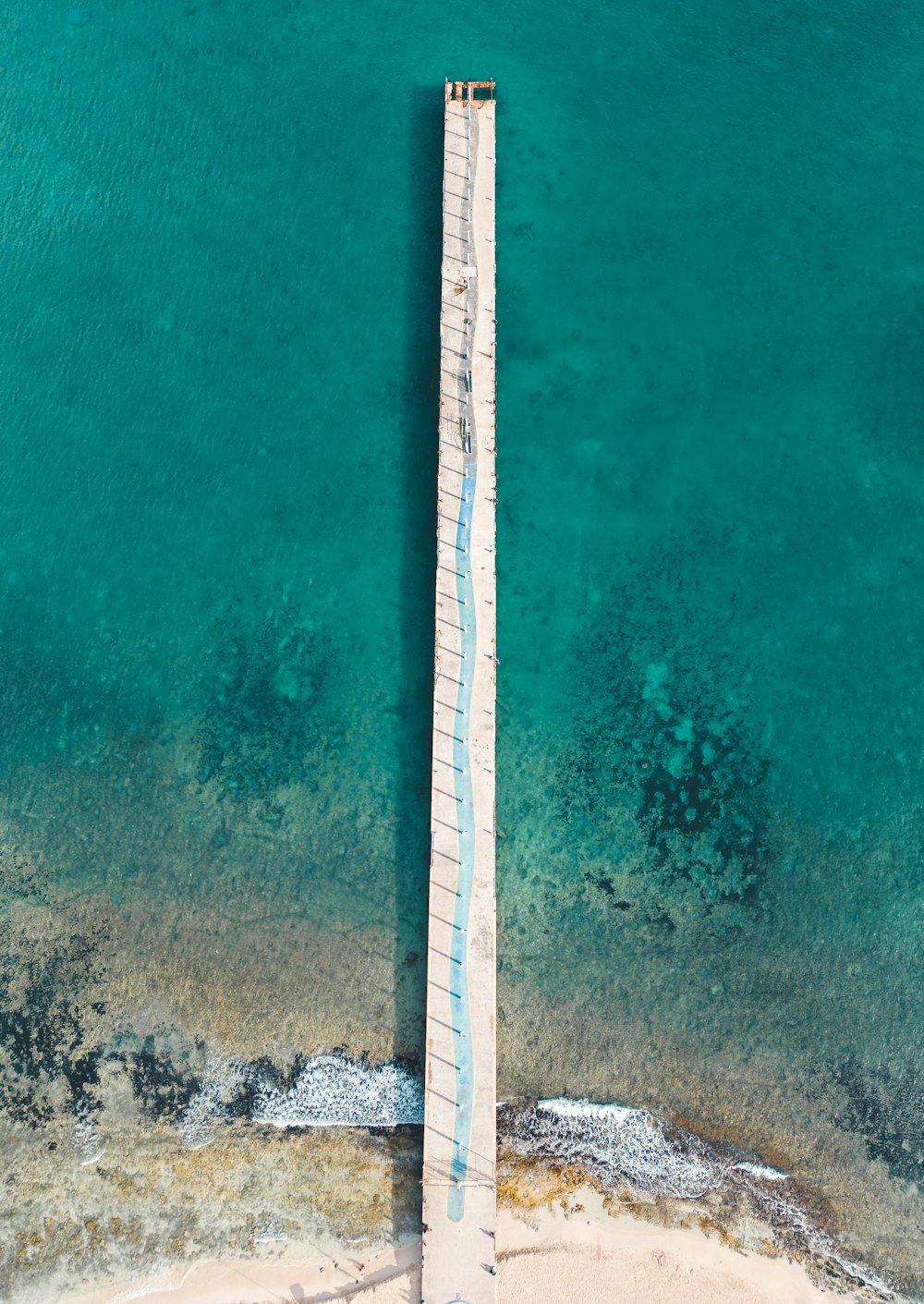 an aerial view of a pier in the ocean