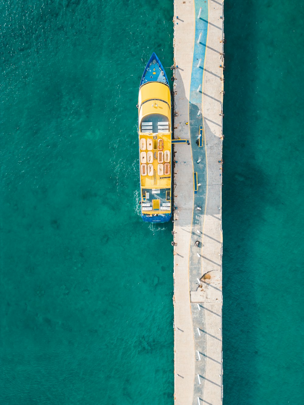 a yellow and blue boat floating on top of a body of water