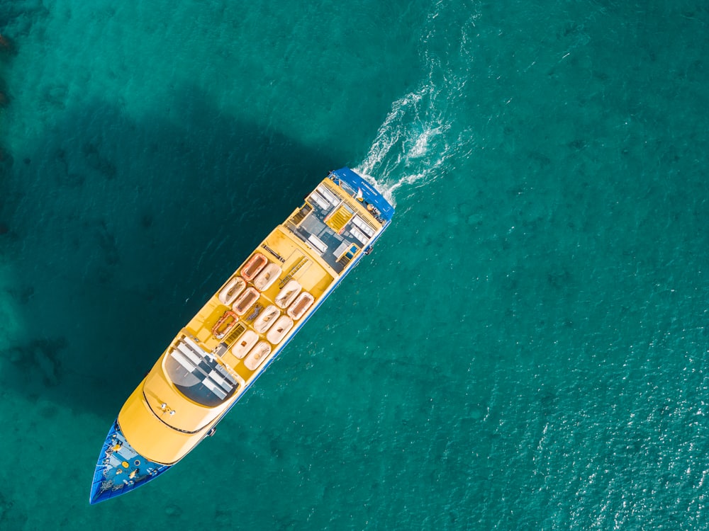 a yellow and blue boat floating on top of a body of water