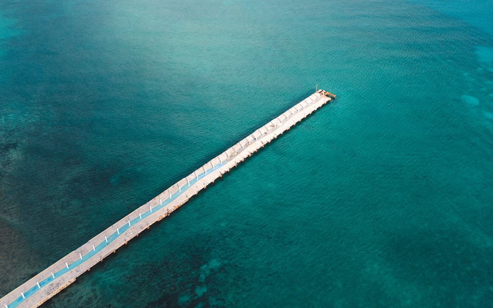 an aerial view of a pier in the middle of the ocean