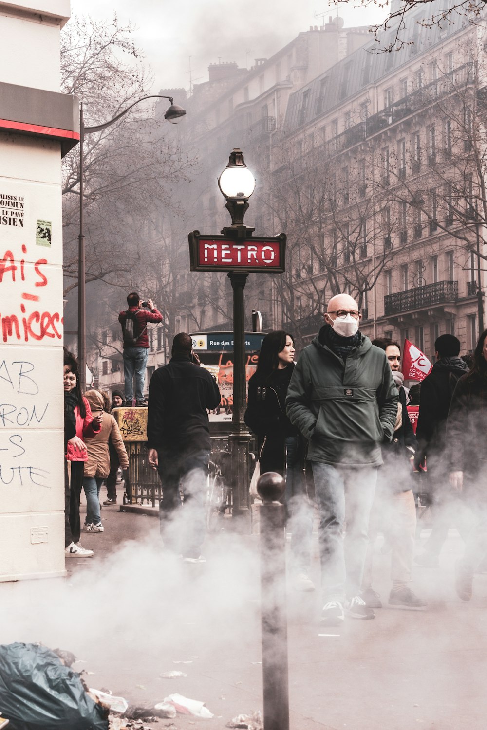 a man in a face mask standing on a street corner