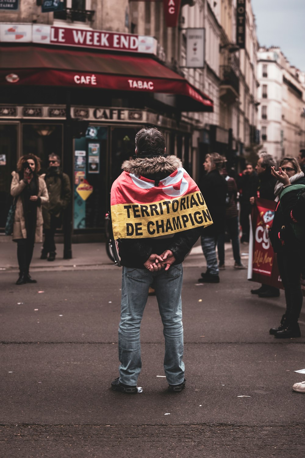 a man standing on a street holding a sign