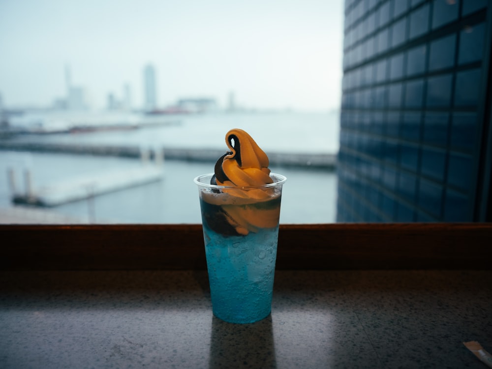 a banana sitting in a cup on a window sill