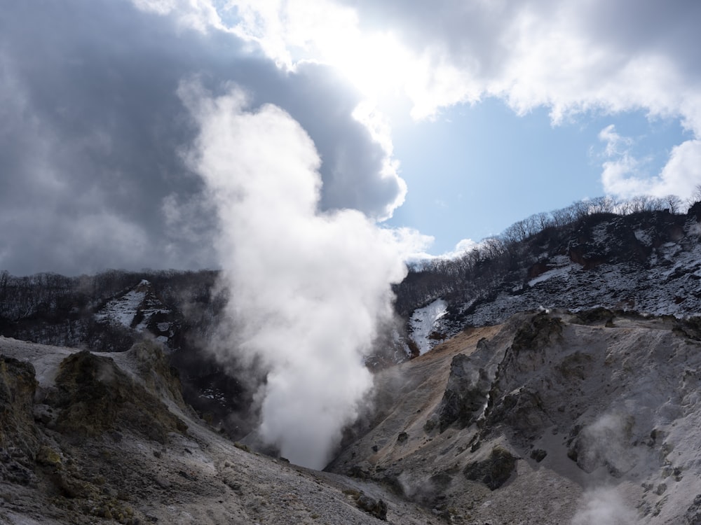 steam rises from a geyser in a mountainous area