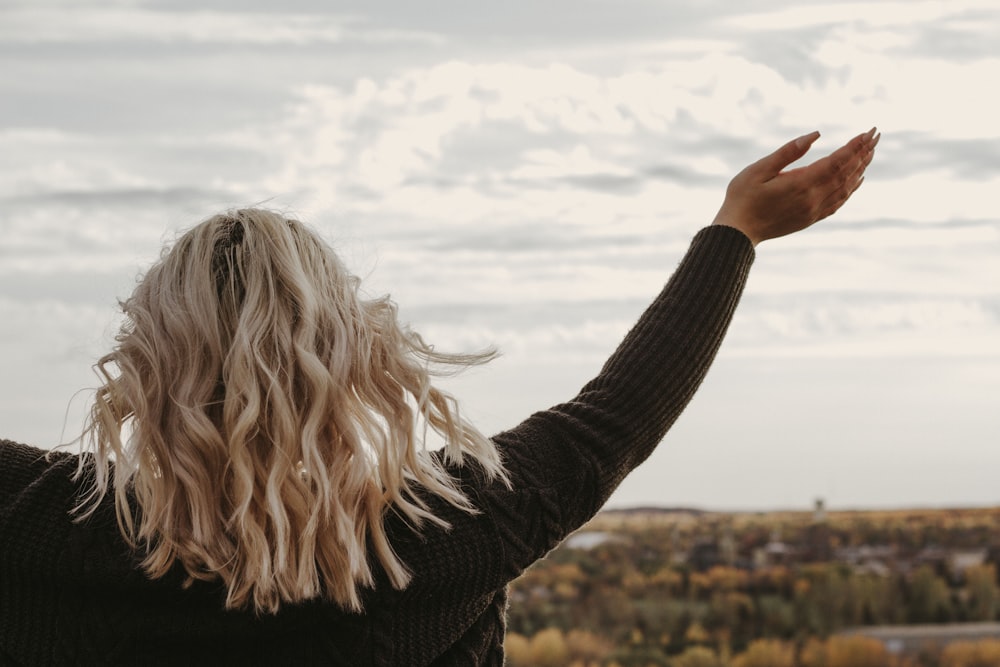 a woman with blonde hair is flying a kite