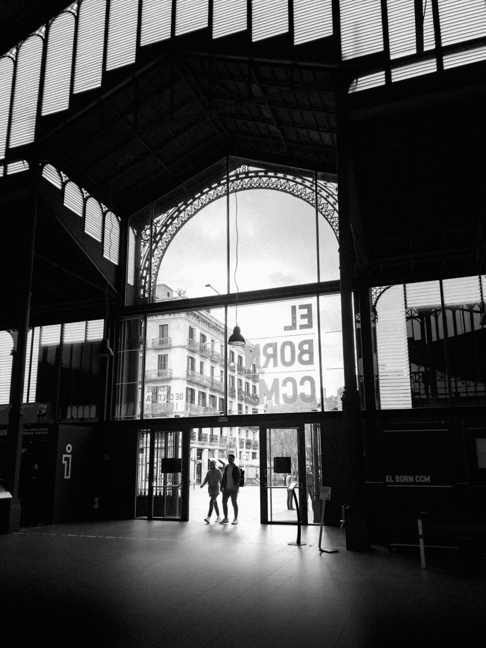 Una foto en blanco y negro de personas entrando en una estación de tren