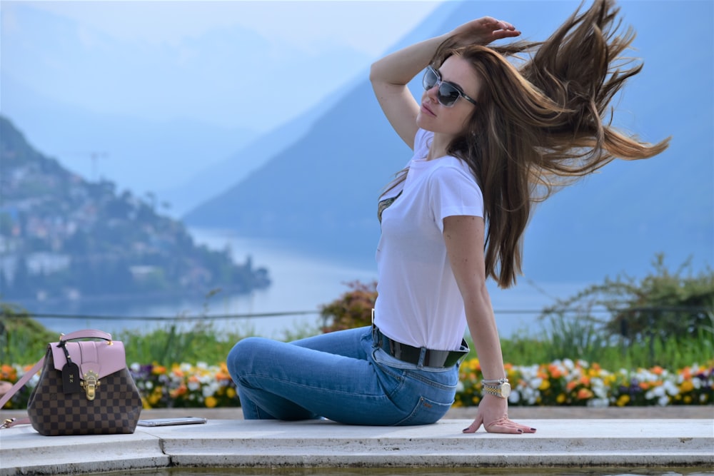 a woman sitting on the ground with her hair in the wind