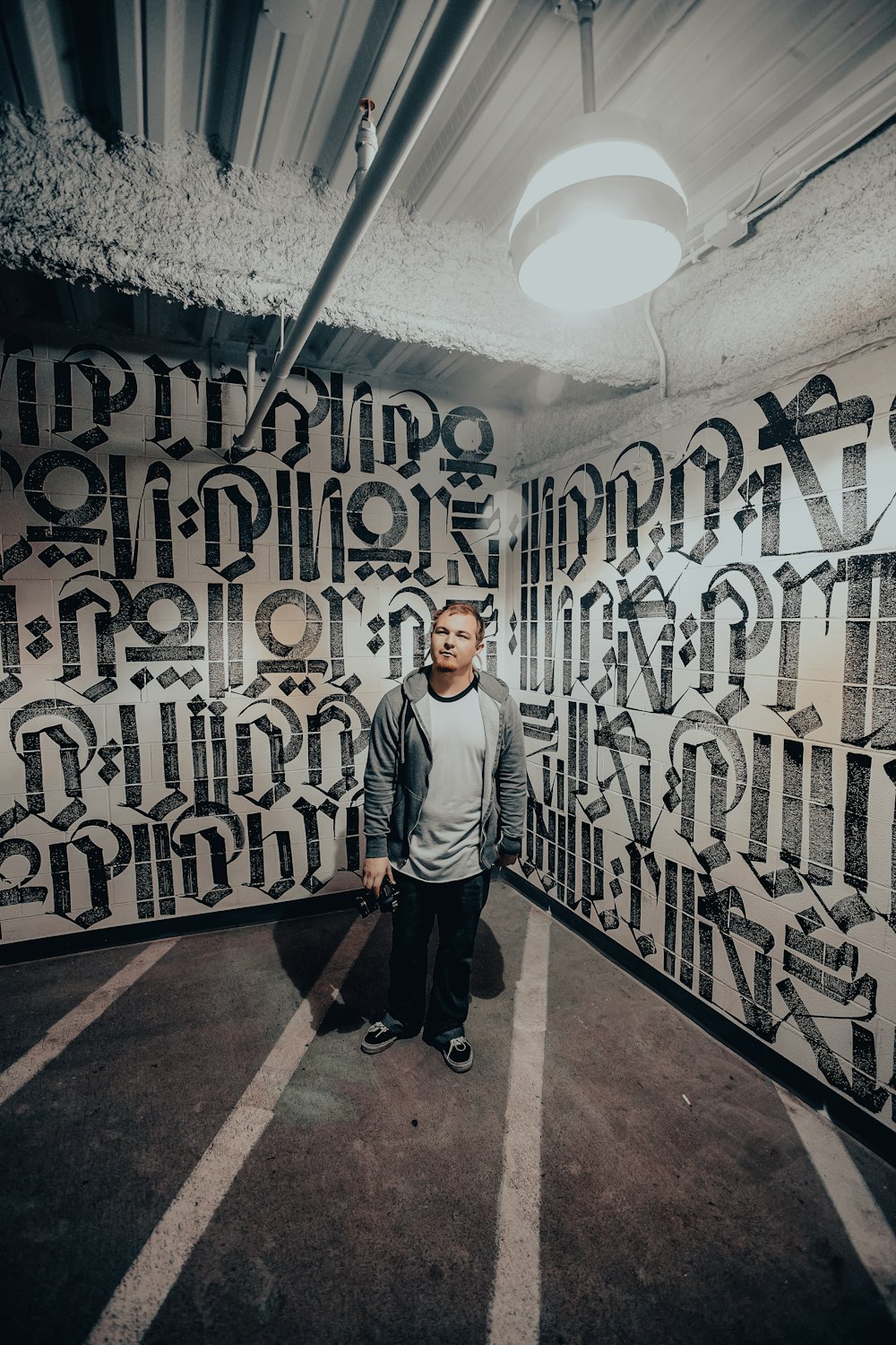 a man standing in front of a wall covered in graffiti