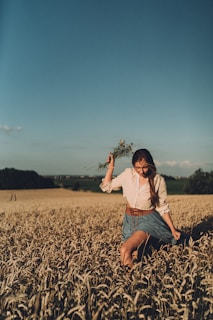 A farmer carefully harvesting wild herbs in a sunlit meadow, showcasing sustainable practices.