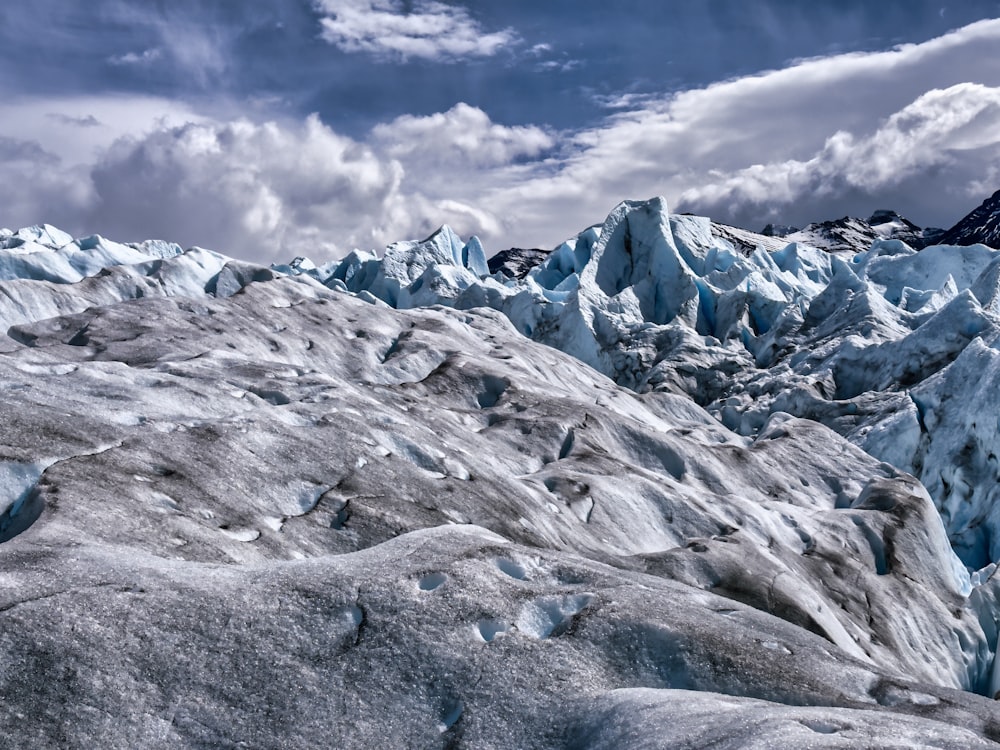 Una montagna molto grande coperta di neve sotto un cielo nuvoloso