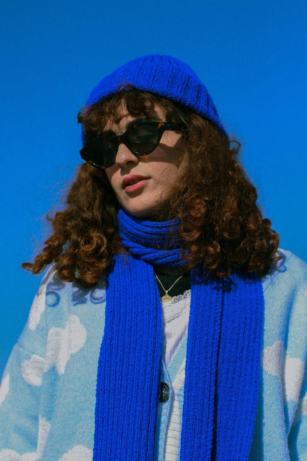 una donna che porta occhiali da sole e una sciarpa blu