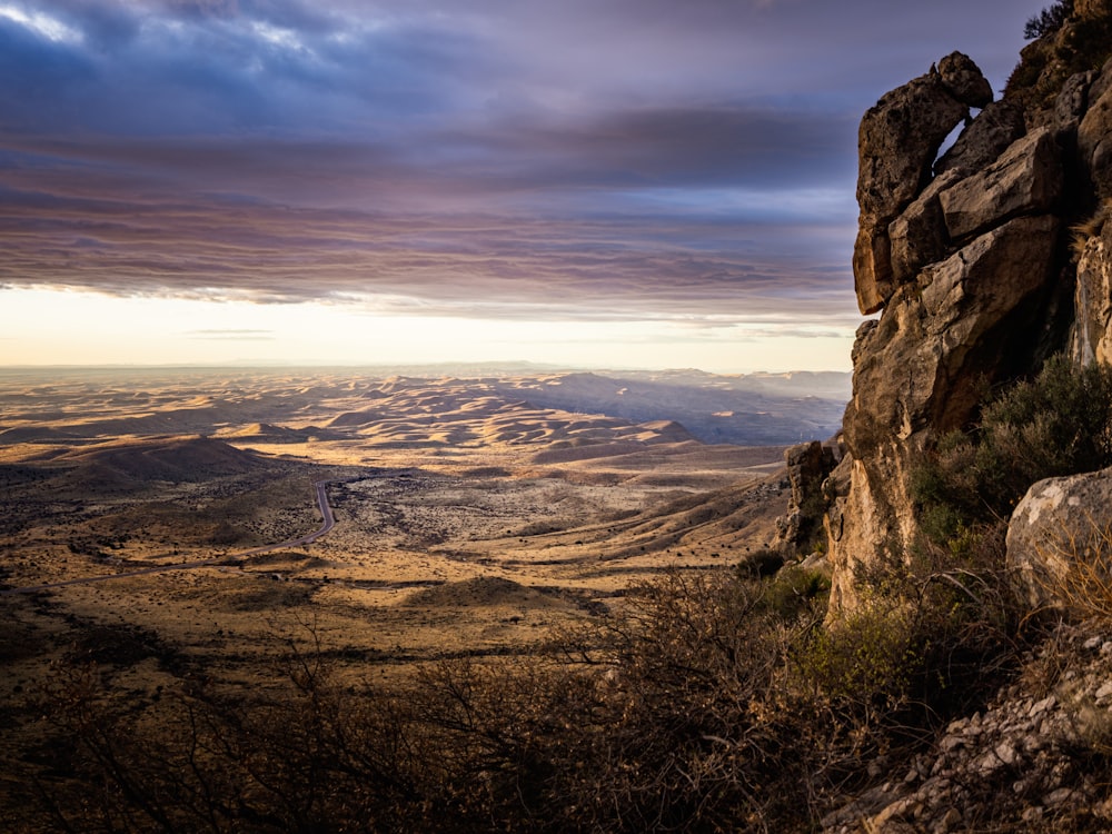 a view of a valley from a rocky cliff