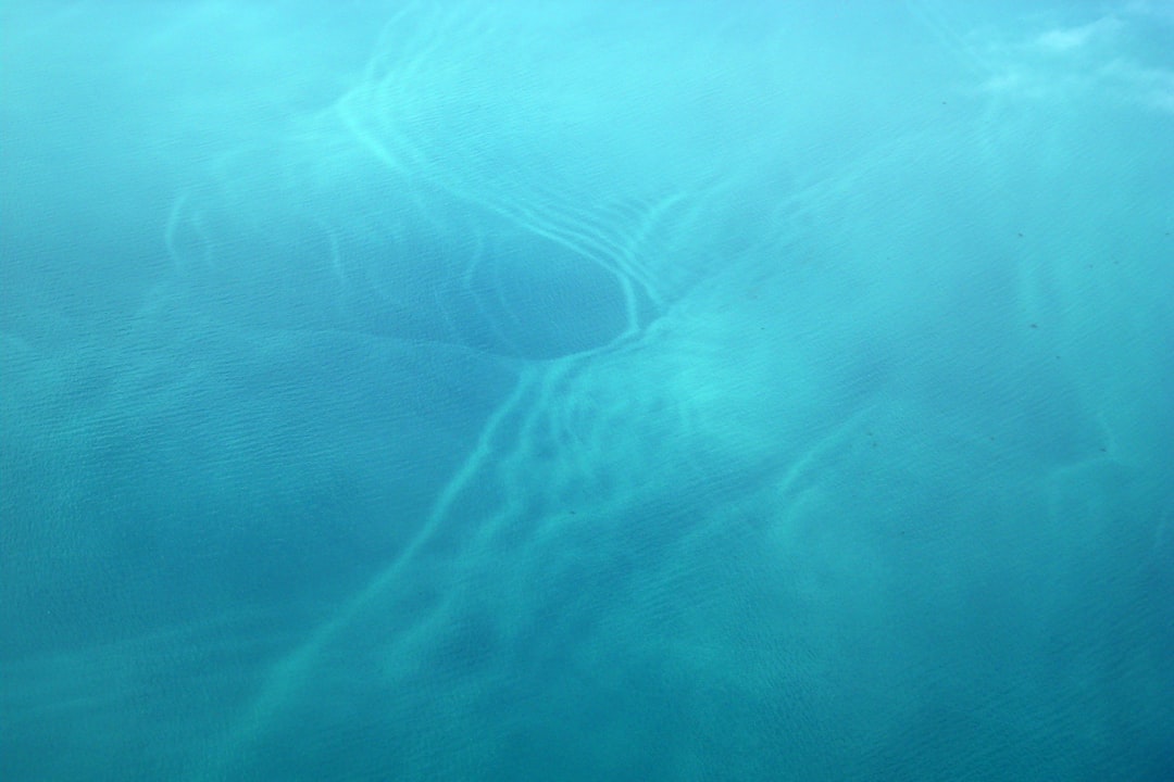 a plane flying over a body of water,