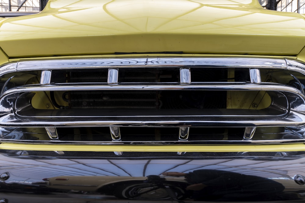 a close up of the front grill of a yellow truck