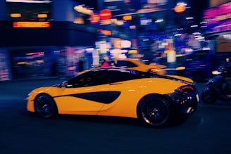 A sleek racing car speeding through neon-lit urban roads at night.
