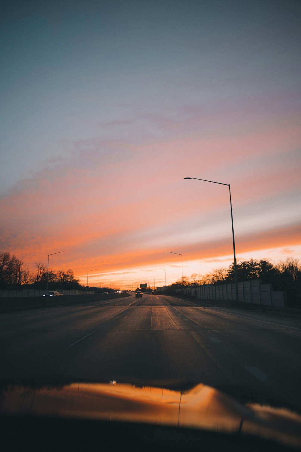 the sun is setting on the horizon of a street