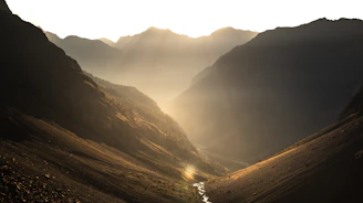 A serene mountain valley in West China bathed in golden morning light.