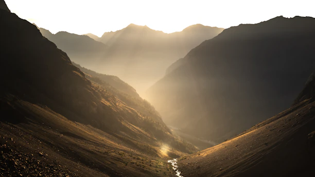 A serene mountain valley in West China bathed in golden morning light.