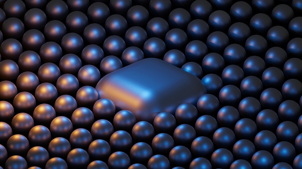 a group of shiny balls with a square shaped object in the middle