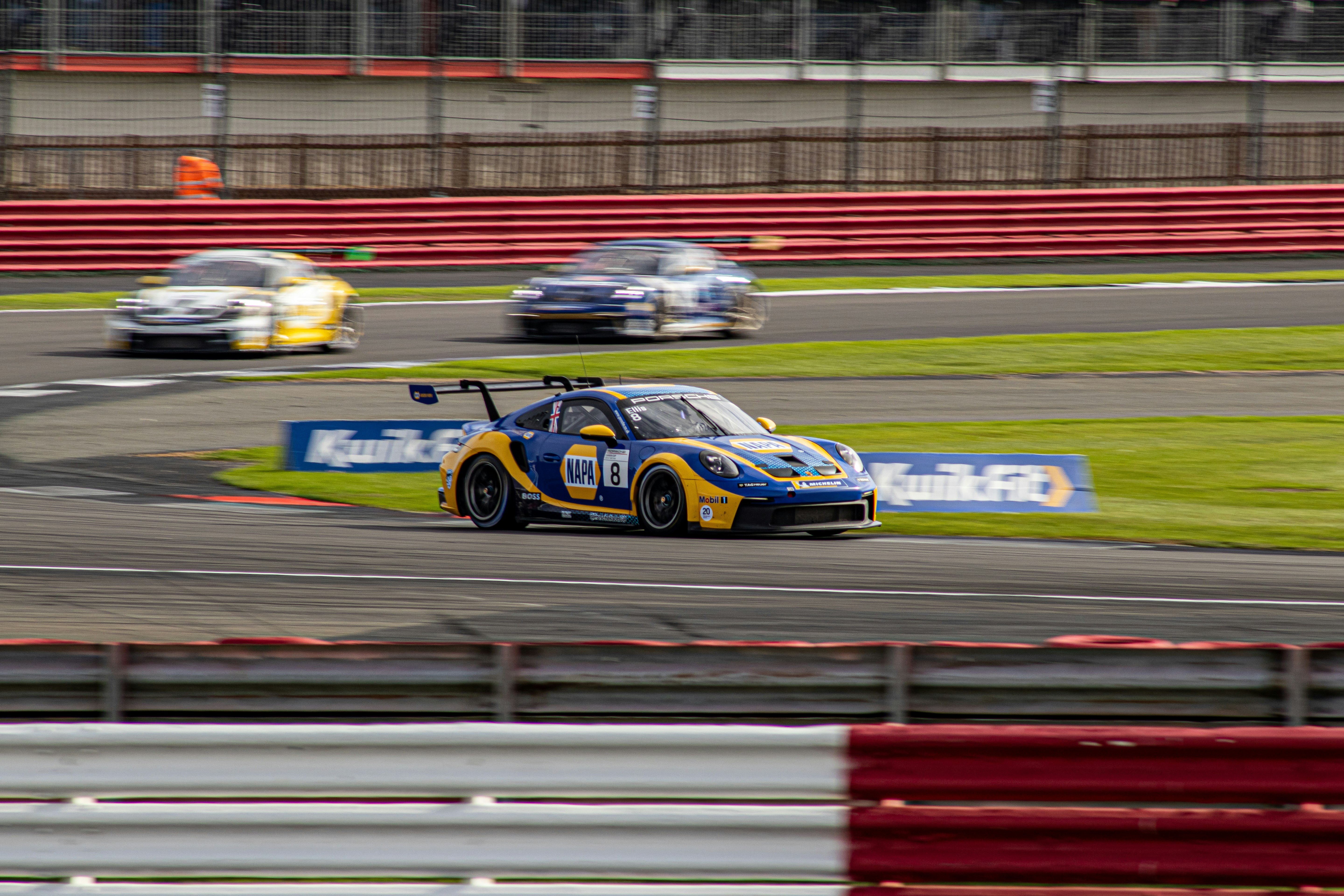 a yellow and blue car driving on a race track
