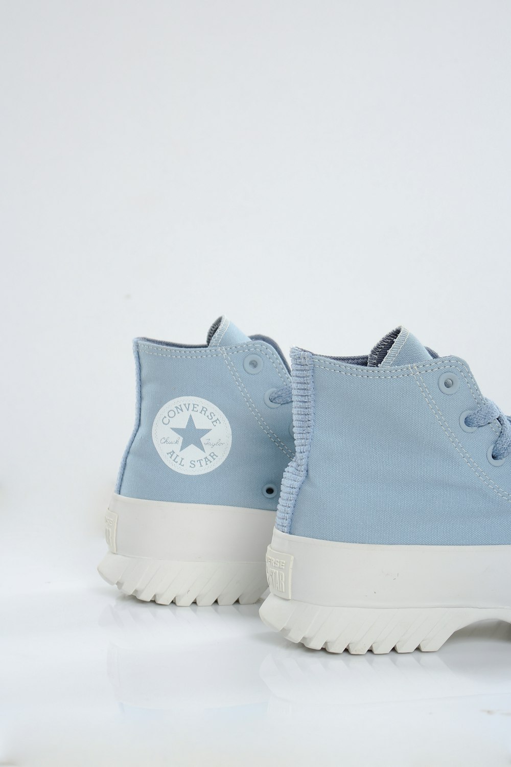 a pair of blue converse sneakers on a white background