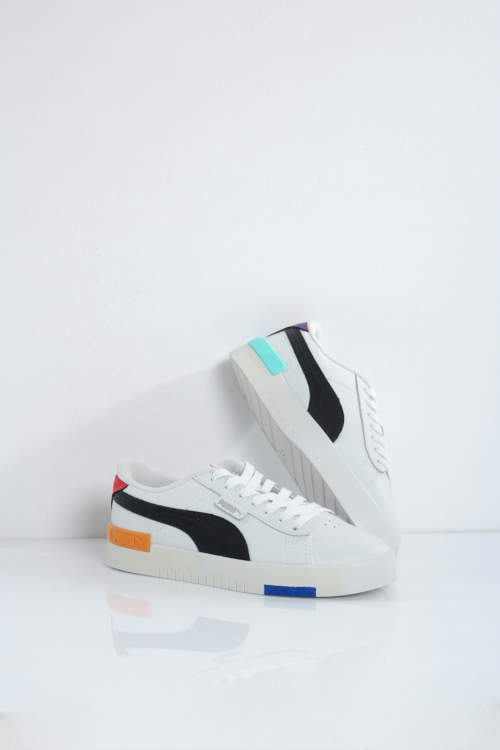 une paire de baskets blanches et noires sur une surface blanche