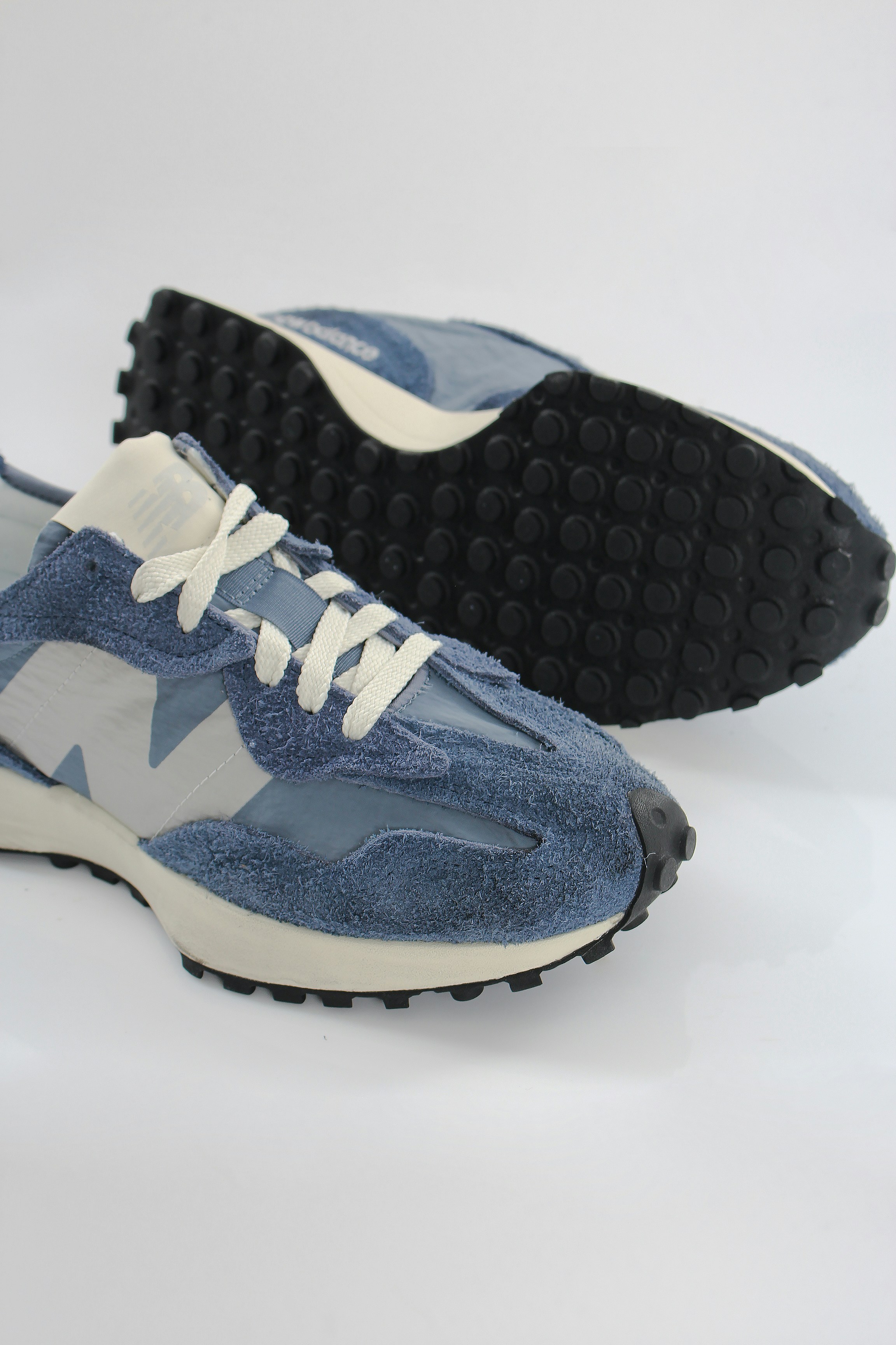 a pair of blue and white sneakers on a white background