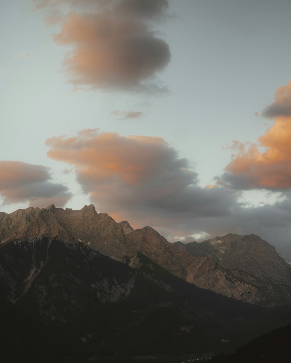 a view of a mountain range with clouds in the sky