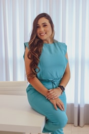 a woman sitting on a table in a blue dress