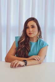 a woman sitting at a table with her arms crossed