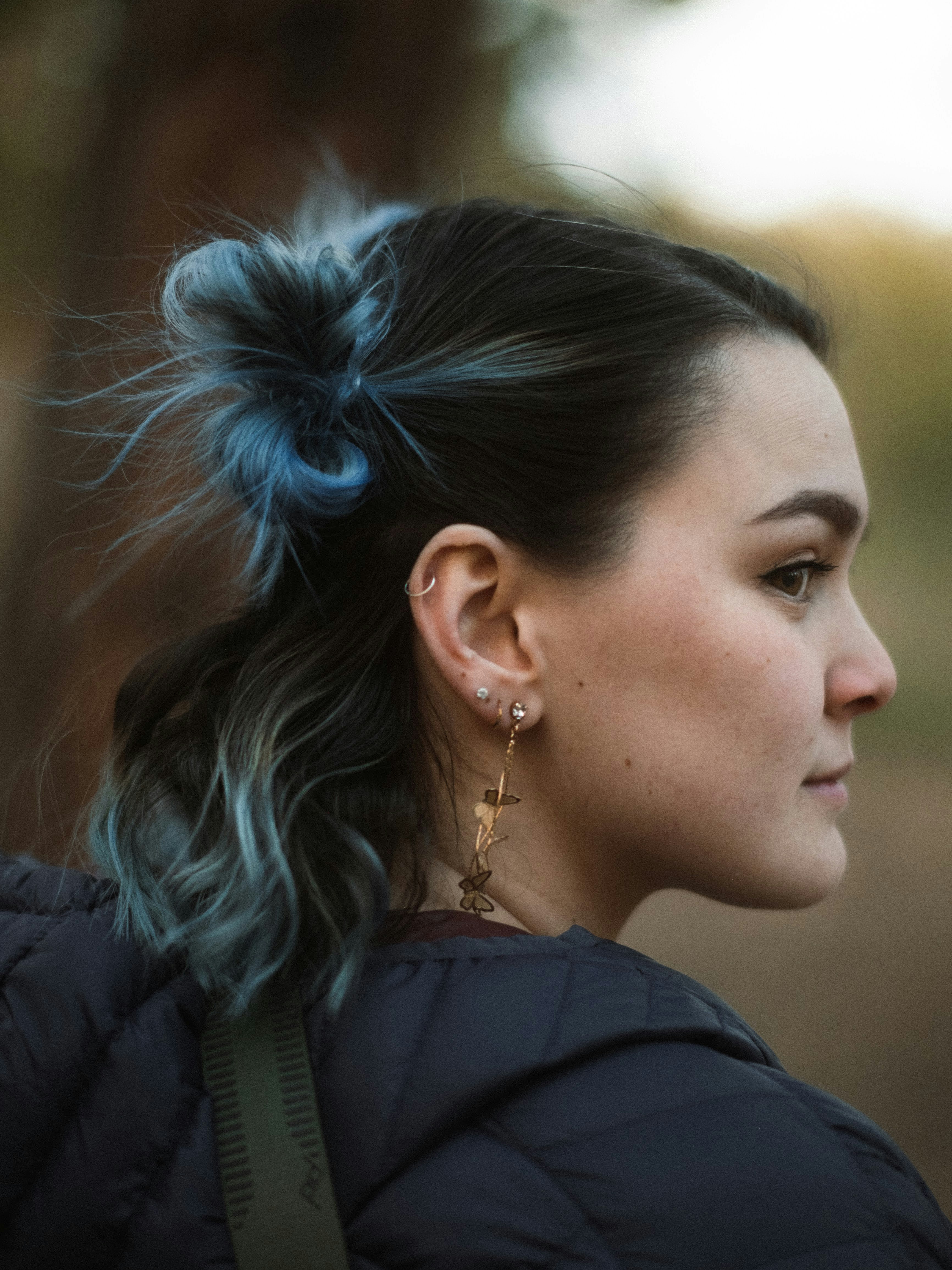 a woman with blue hair wearing a black jacket