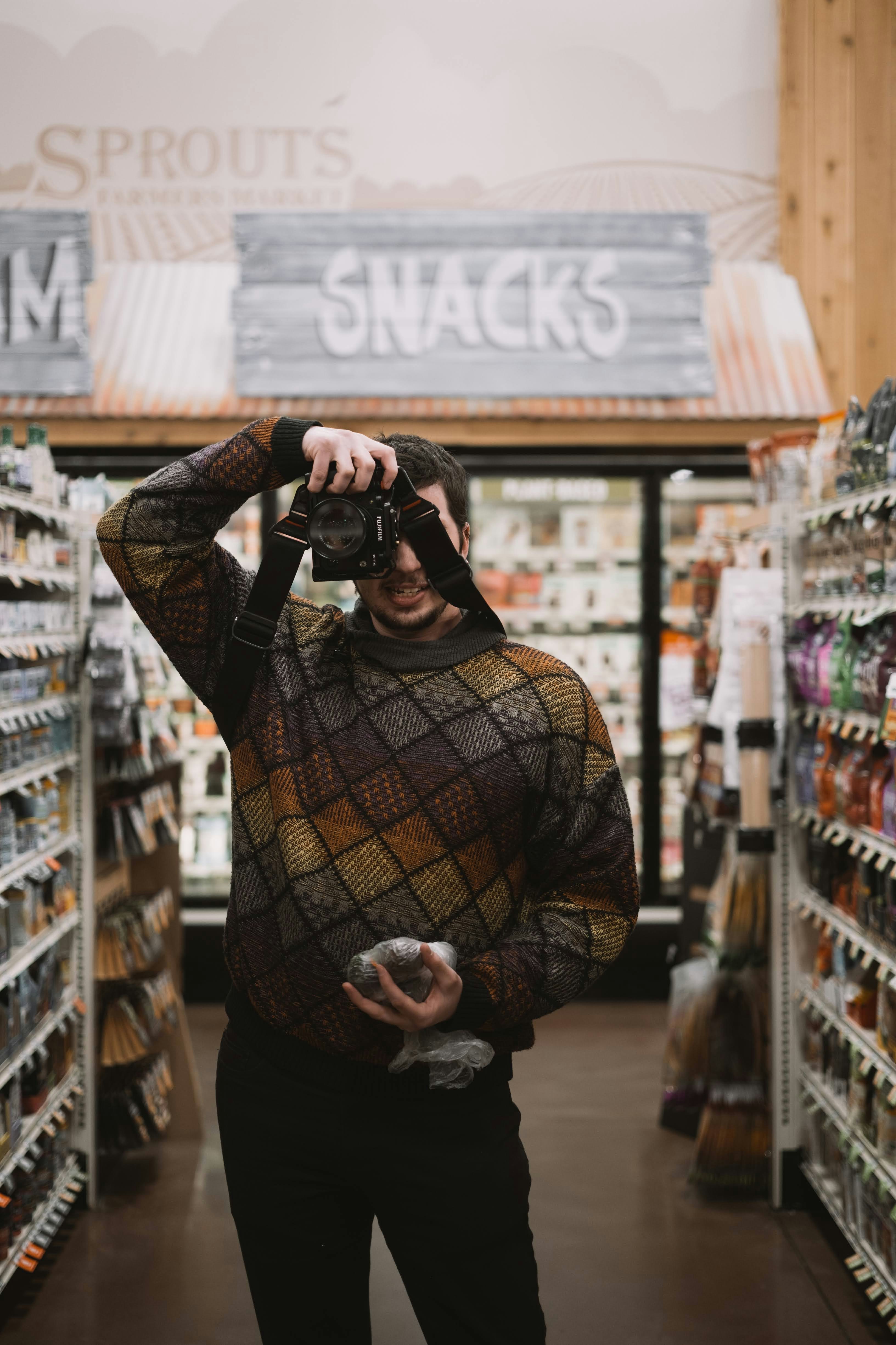 a man standing in a store looking through a pair of binoculars
