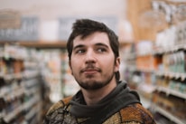A close-up of a customer examining a selection of building supplies with a thoughtful expression.