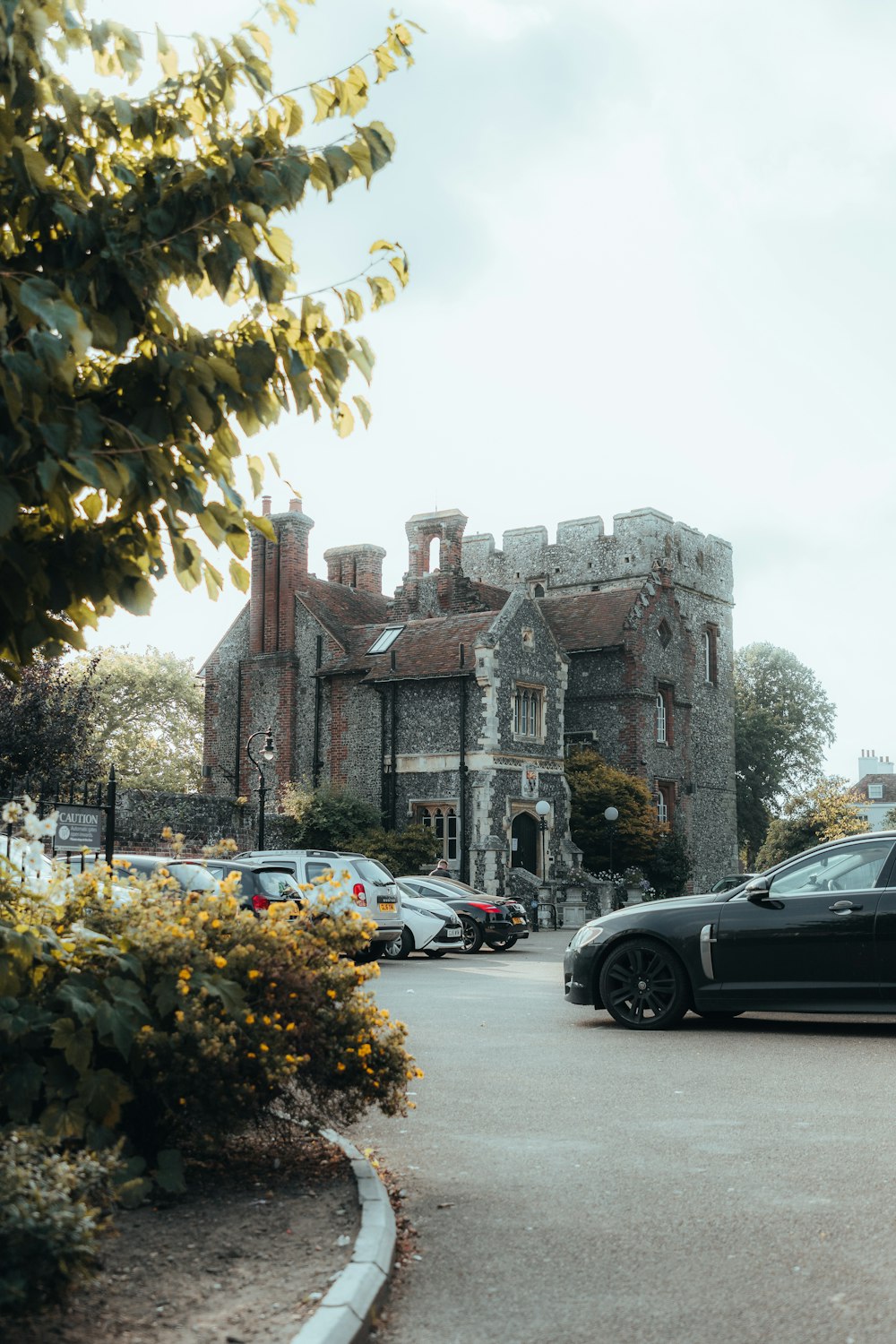 a black car is parked in front of a castle