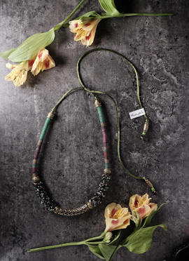 Artisan hands carefully stringing beads to create a unique, handcrafted necklace.